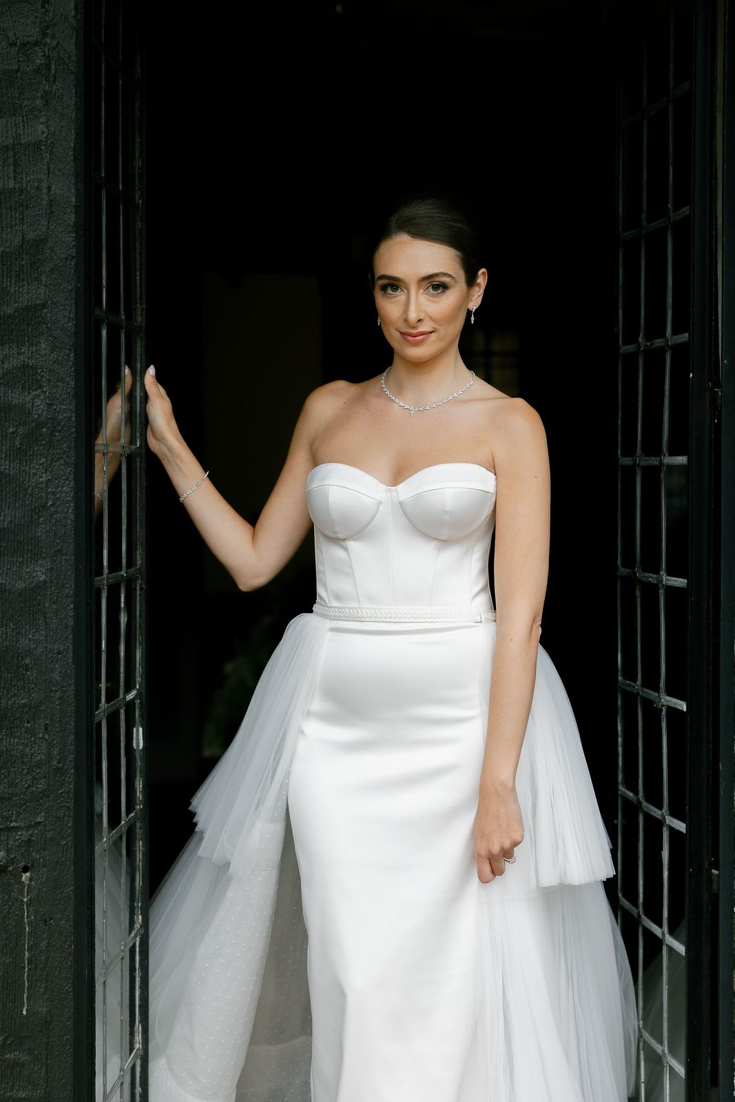 A bride standing in an iron framed doorway