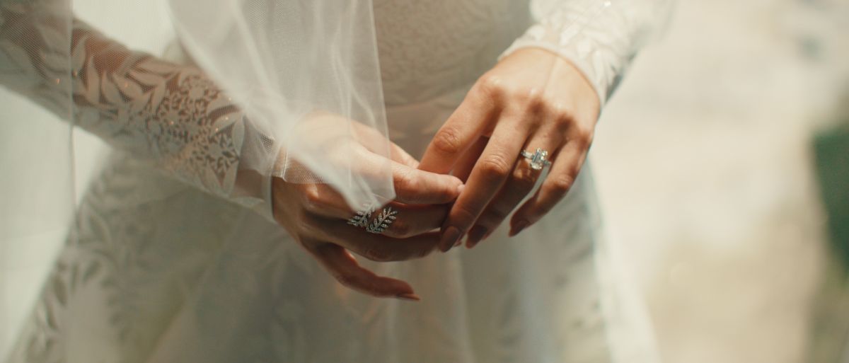 A bride holding her hands, rings catching the light