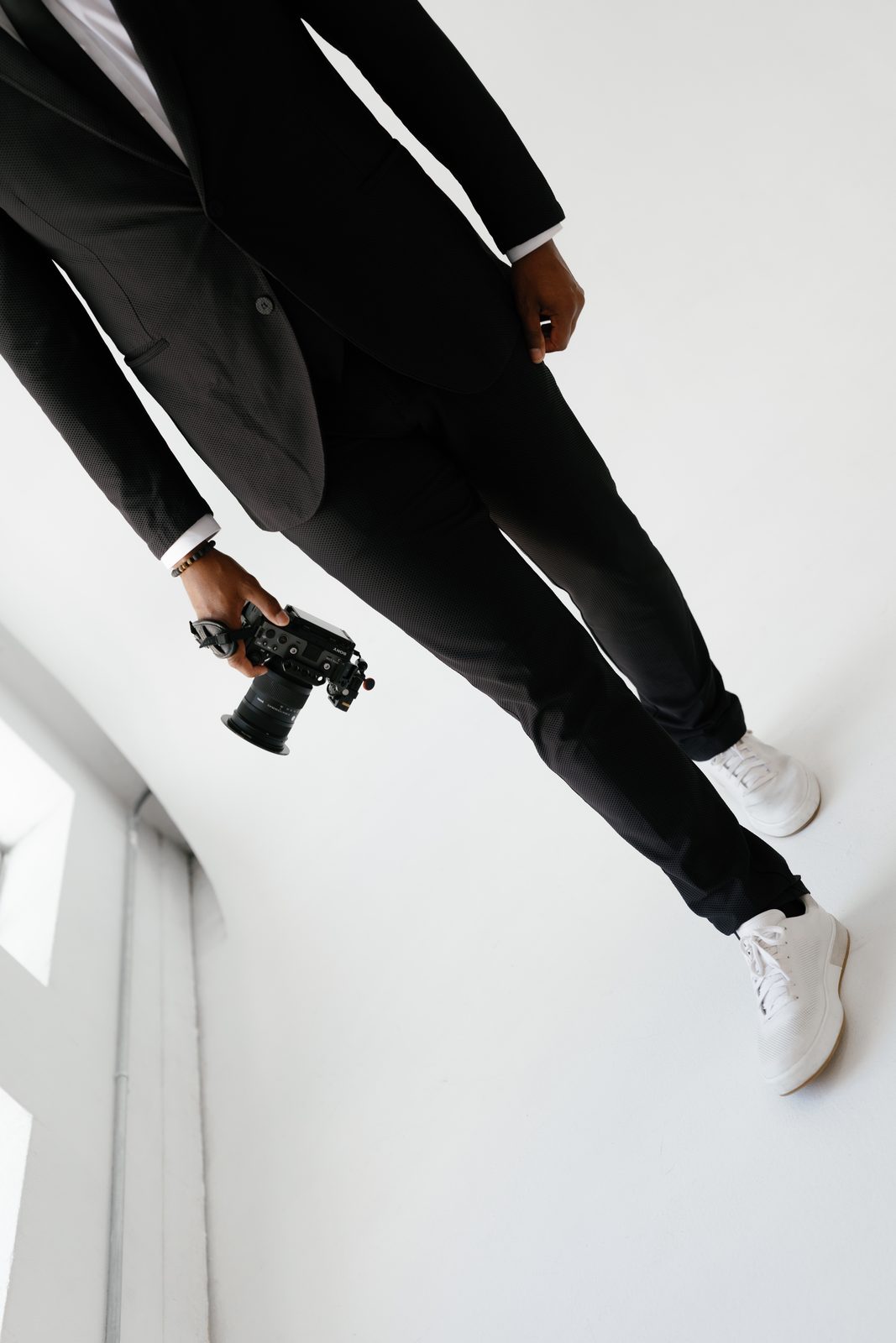 Javi in a black suit holding a cinema camera
