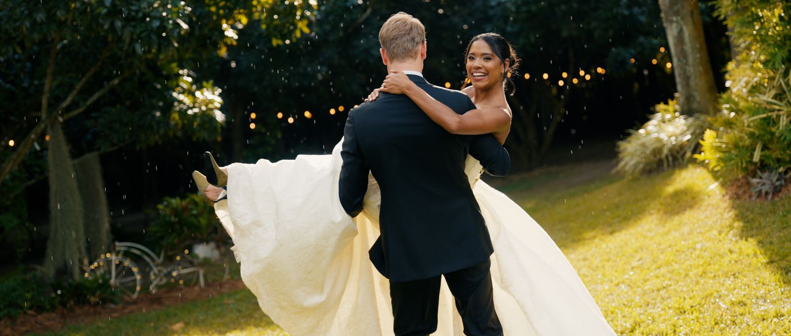 Trent carrying Karla across a garden in the rain