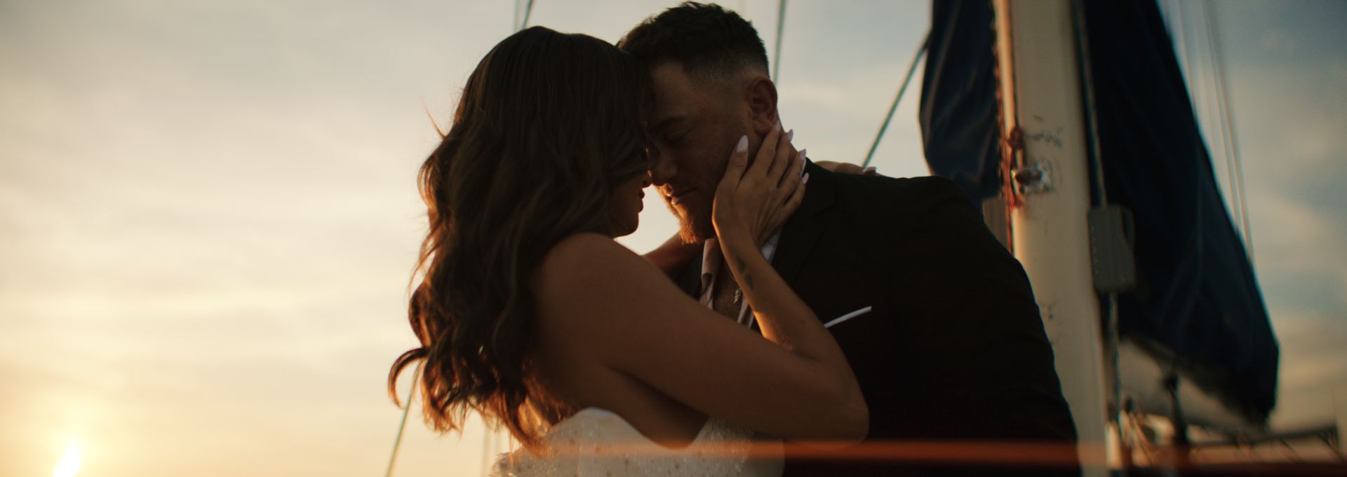A couple embracing on a sailboat at sunset