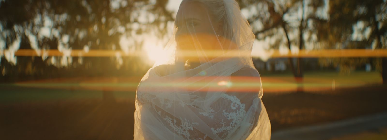 A bride wrapped in her veil at golden hour