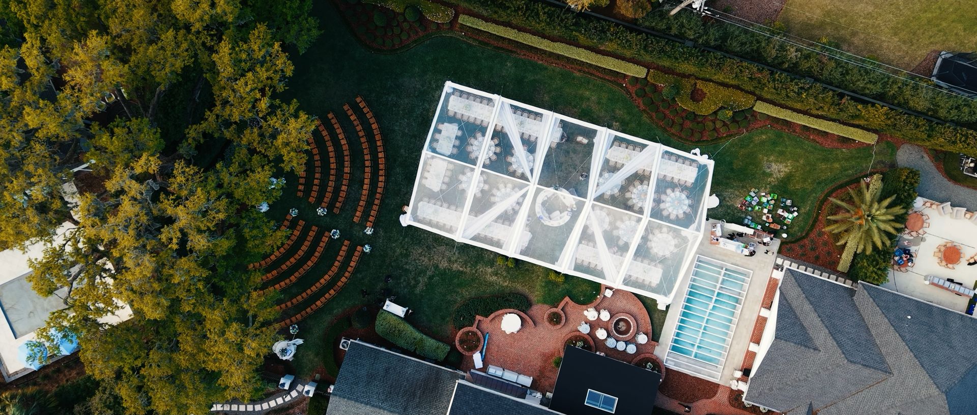 An aerial view of a tented reception and ceremony seating on a private estate