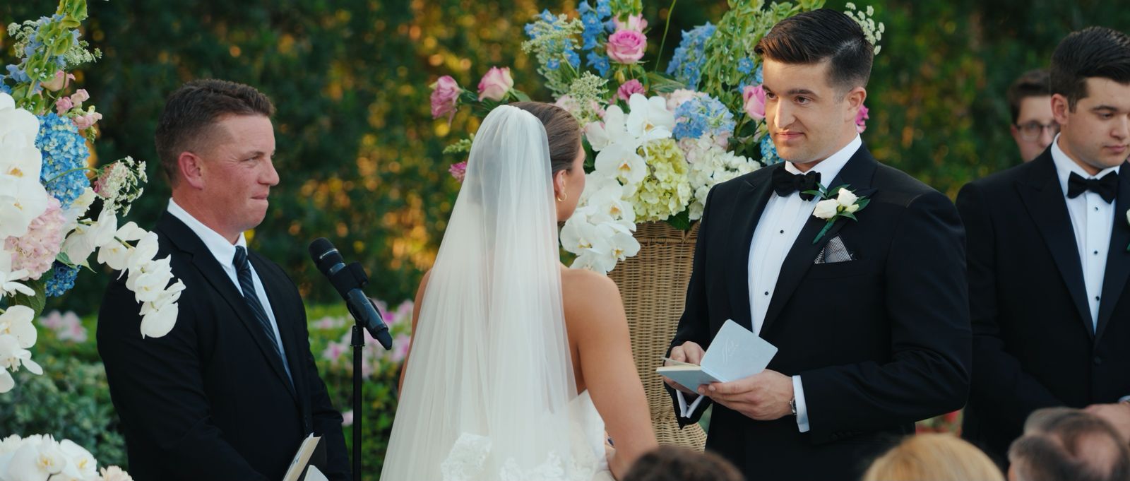 A groom reading his vows beside the ceremony microphone